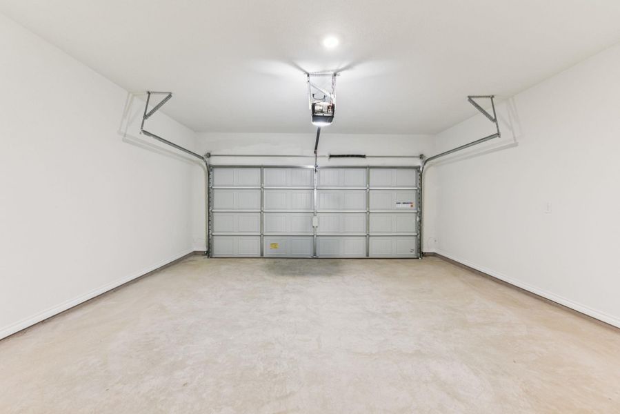 Garage with a garage door opener and baseboards Garage with a garage door opener and baseboards