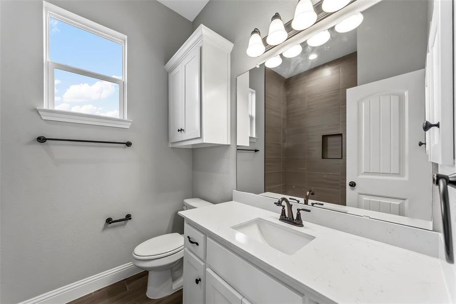 Bathroom with hardwood / wood-style floors, vanity, and toilet