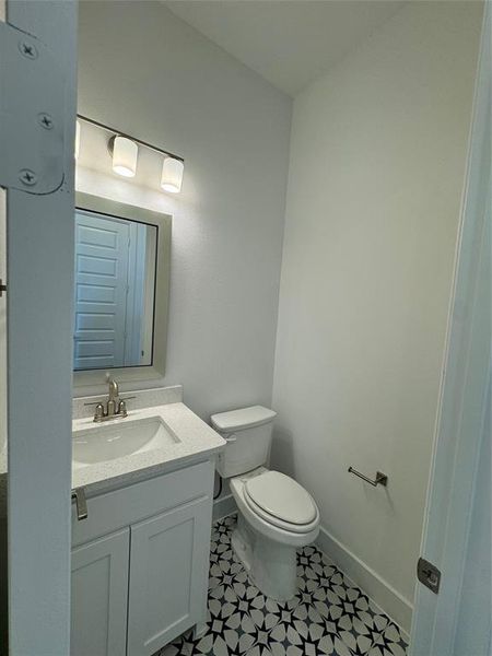 Bathroom with tile patterned floors, vanity, and toilet