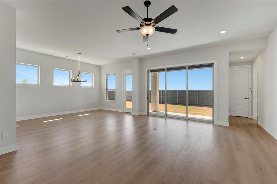 Empty room featuring ceiling fan, healthy amount of natural light, dark wood-type flooring, and recessed lighting