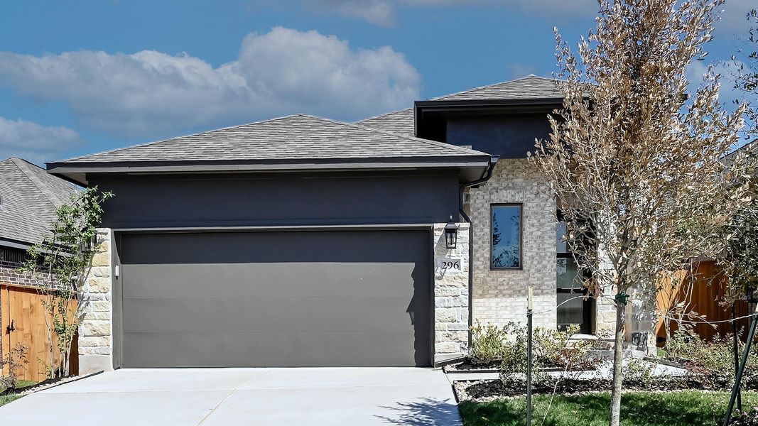 View of front of property featuring stone siding, a garage, roof with shingles, stucco siding, and driveway View of front of property featuring stone siding, a garage, roof with shingles, stucco siding, and driveway