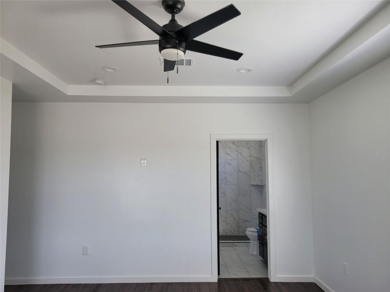 Empty room featuring ceiling fan, recessed lighting, and a tray ceiling