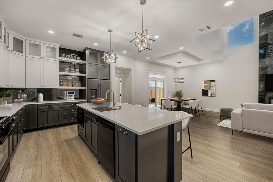 The large center island overlooks the great room open floor plan and invites guests to gather along the breakfast bar seating. (virtually staged photo)