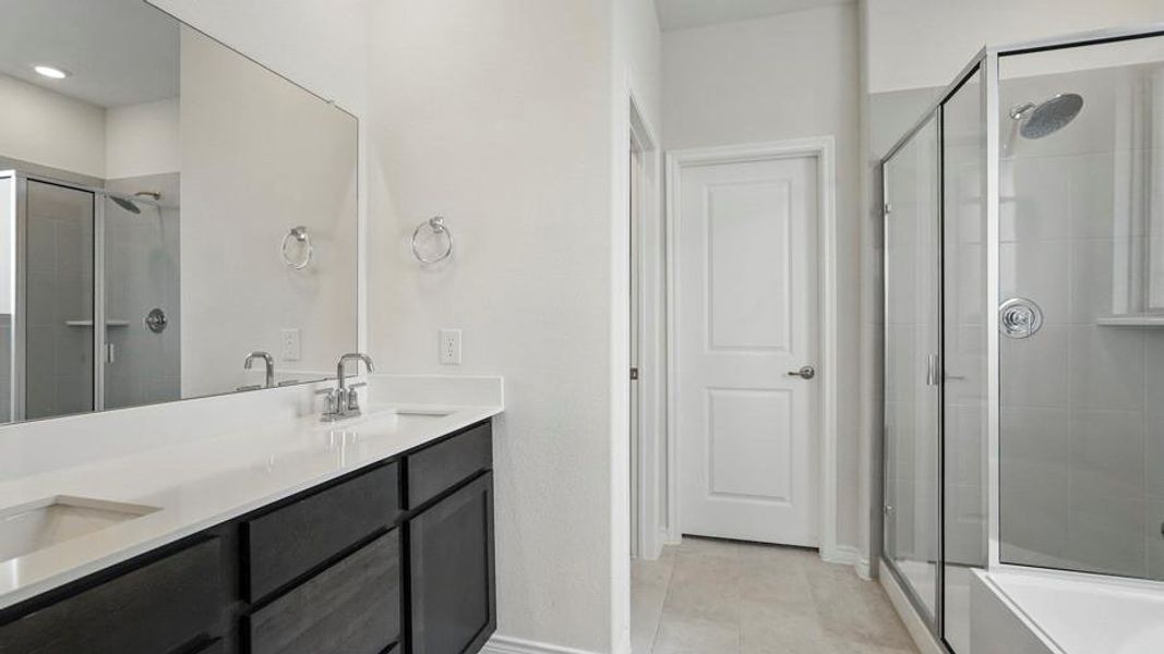 Double vanity with white countertop, chrome fixtures, and dark wood-finish cabinetry