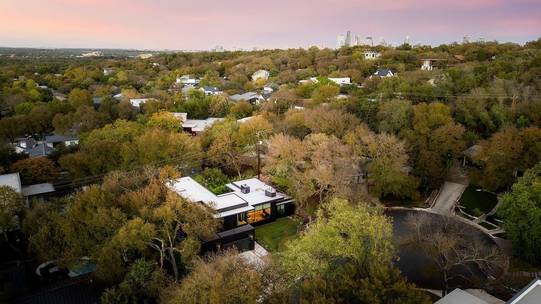 Set on a quarter-acre lot, this contemporary residence is enveloped by lush professional landscaping that harmonizes with the natural beauty of the tree-filled rolling hills.