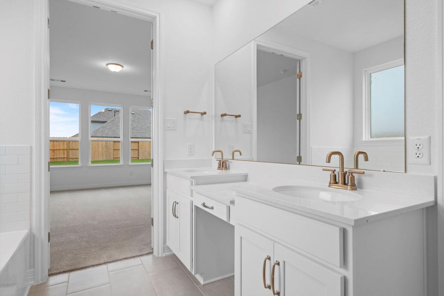 The en-suite bathroom offers a spa-like atmosphere with its elegant design, high end finishes, and tasteful lighting, creating a retreat within your own home.