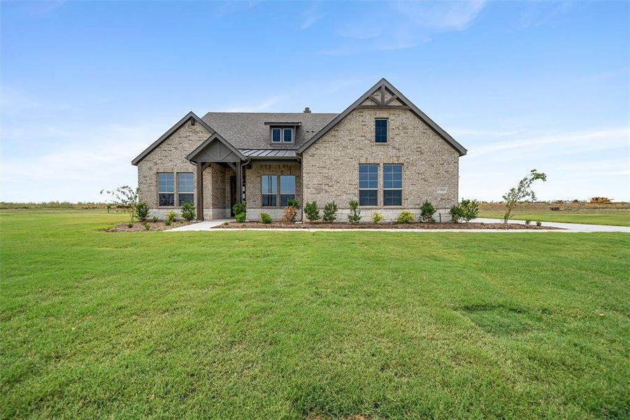 View of front of property with a standing seam roof, brick siding, a metal roof, and a front lawn View of front of property with a standing seam roof, brick siding, a metal roof, and a front lawn