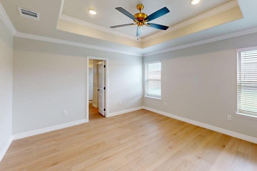 Unfurnished room with a raised ceiling, ornamental molding, light wood-type flooring, a ceiling fan, and recessed lighting
