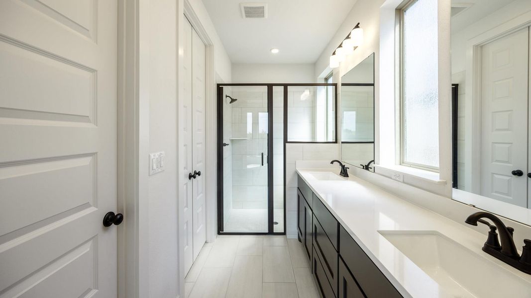 Full bathroom featuring a stall shower, double vanity, and recessed lighting Full bathroom featuring a stall shower, double vanity, and recessed lighting