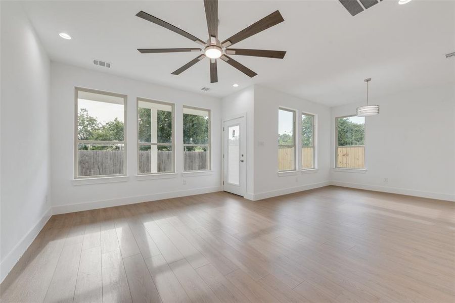 Empty room featuring healthy amount of natural light, light wood-type flooring, recessed lighting, and a ceiling fan Empty room featuring healthy amount of natural light, light wood-type flooring, recessed lighting, and a ceiling fan