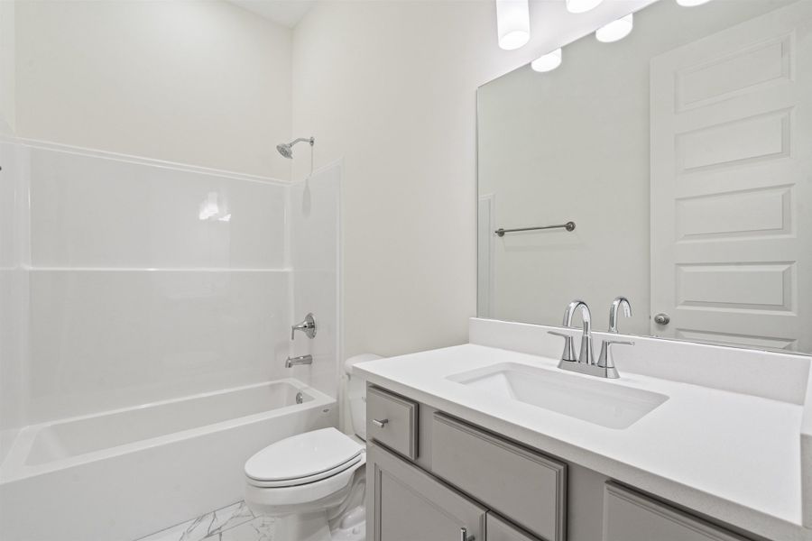 Bathroom with vanity, shower / bath combination, and light marble finish floors