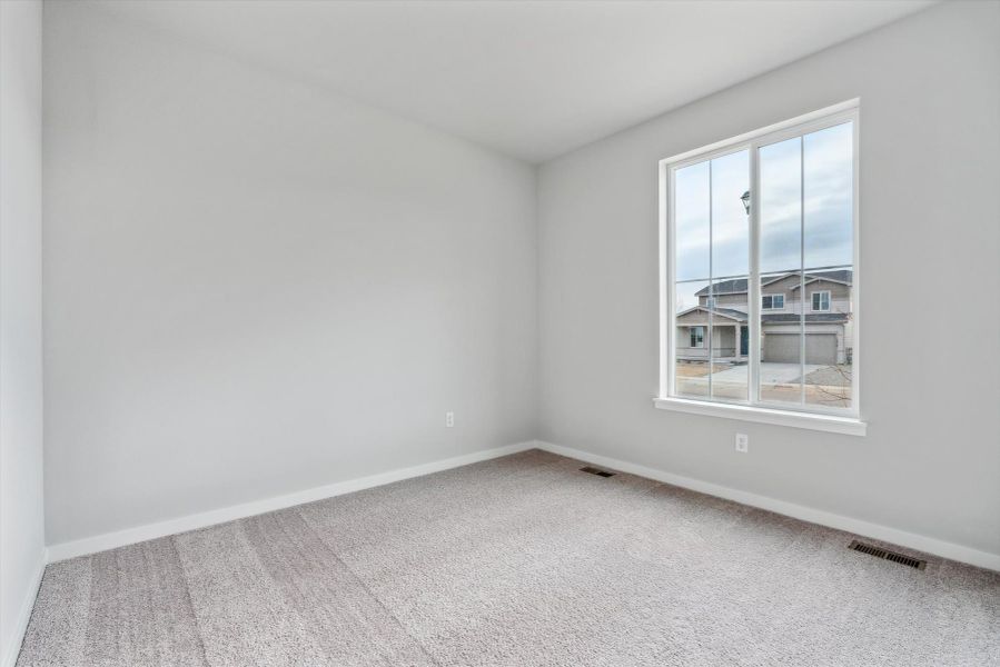 A room with a window and a white wall.