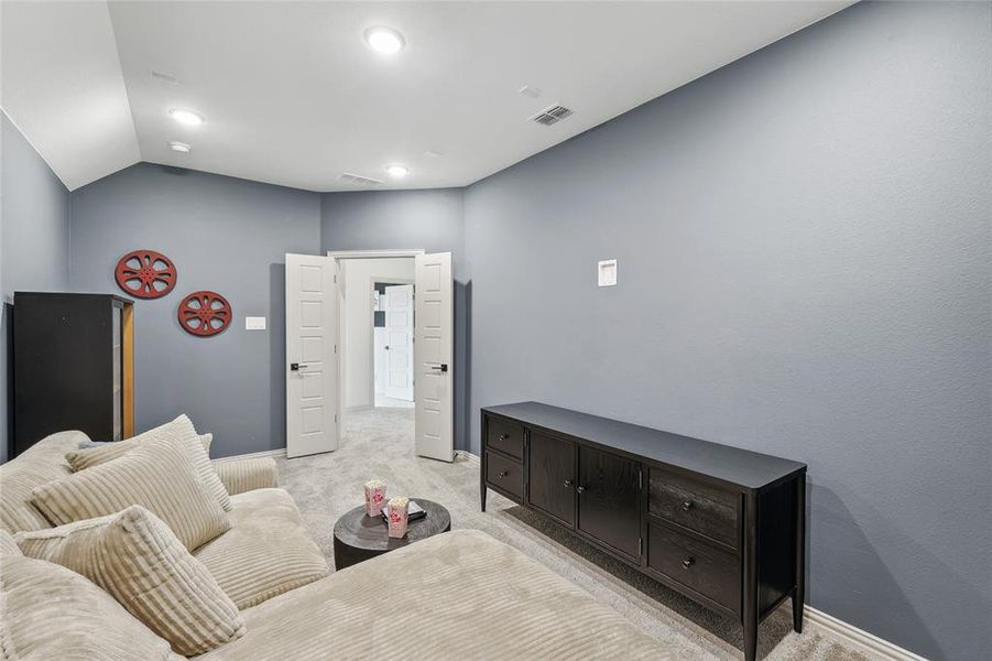 Carpeted bedroom featuring lofted ceiling