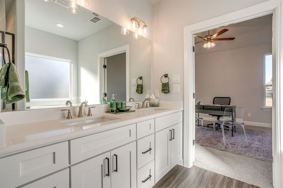 Bathroom with double vanity, ceiling fan, light wood-style flooring, light colored carpet, and recessed lighting