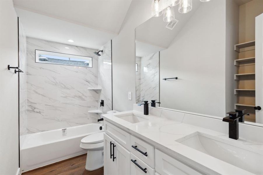 Full bathroom featuring tiled shower / bath, vanity, toilet, and hardwood / wood-style floors