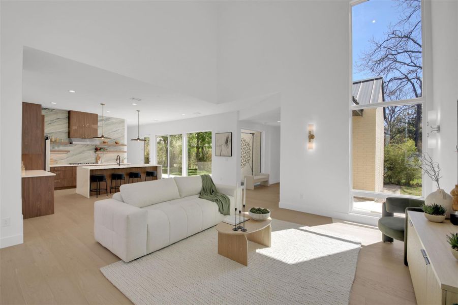 Living area with light wood-style flooring, recessed lighting, and 24' high ceiling