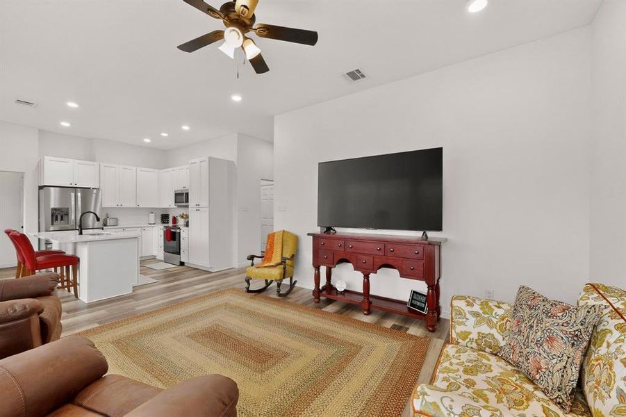 Open-concept living space featuring wood-finish flooring and recessed lighting