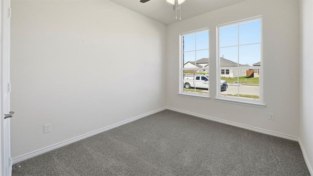 Carpeted empty room with vaulted ceiling and ceiling fan