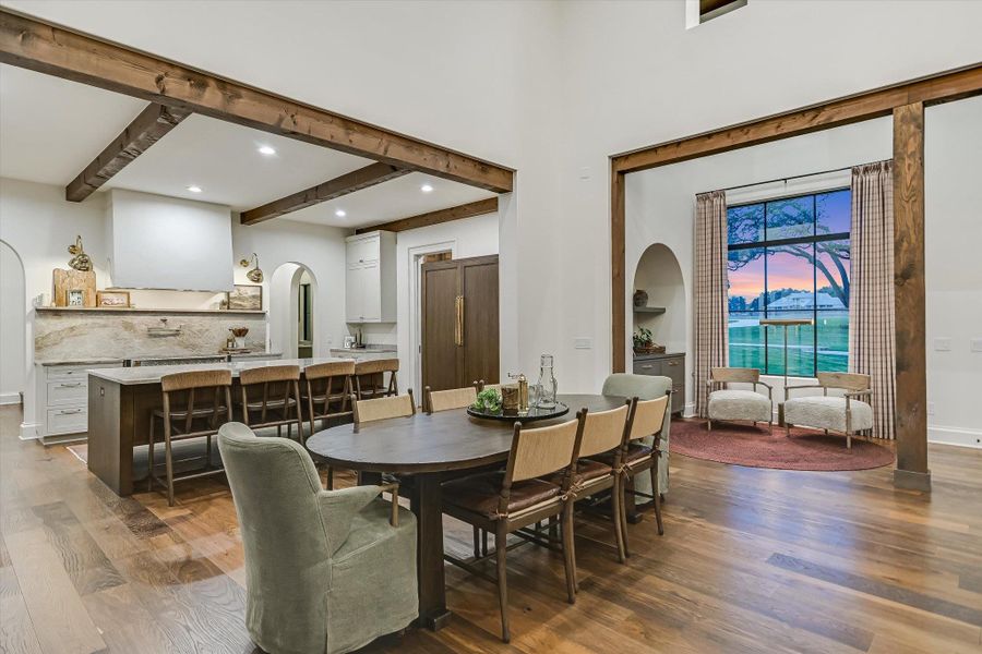 Dining room featuring arched walkways, dark wood finished floors, beam ceiling, and recessed lighting Dining room featuring arched walkways, dark wood finished floors, beam ceiling, and recessed lighting