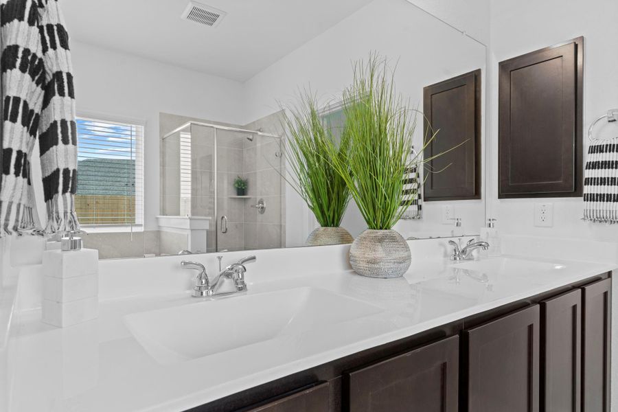 Sleek double vanity with cultured marble countertops, dark cabinetry, and modern fixtures provides ample space for morning routines with a clean, polished finish and even a medicine cabinet. **Image Representative of Plan Only and May Vary as Built**. Sleek double vanity with cultured marble countertops, dark cabinetry, and modern fixtures provides ample space for morning routines with a clean, polished finish and even a medicine cabinet. **Image Representative of Plan Only and May Vary as Built**.