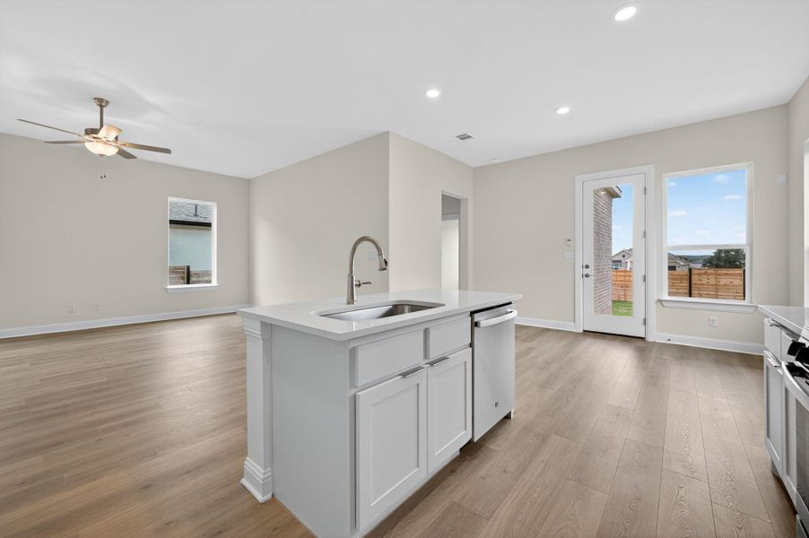 Kitchen featuring white cabinets, recessed lighting, light wood-type flooring, a center island with sink, and open floor plan