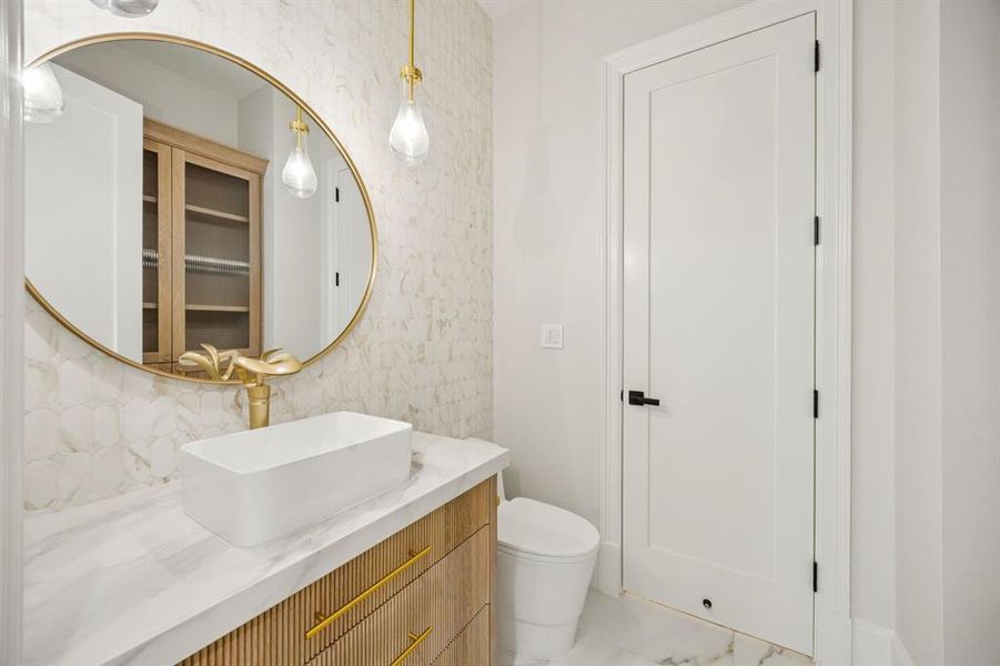 Powder bath has full linen cabinet with reeded glass