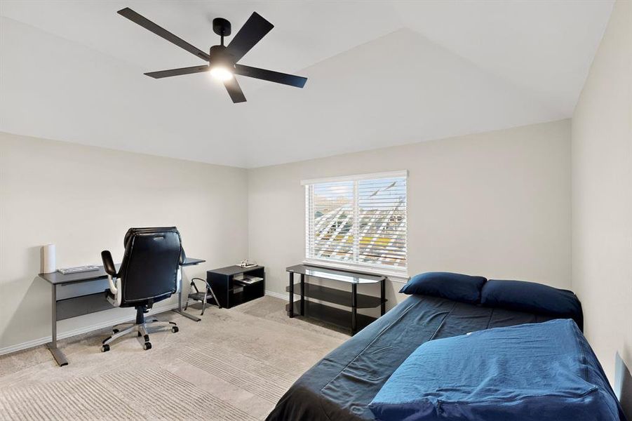 Carpeted bedroom featuring a desk, ceiling fan, and lofted ceiling Carpeted bedroom featuring a desk, ceiling fan, and lofted ceiling
