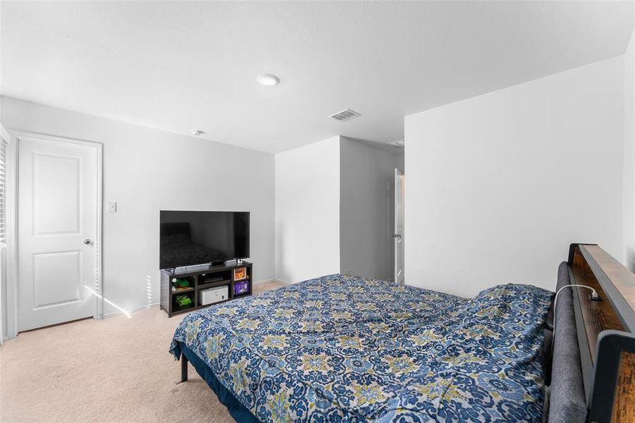 Bedroom featuring light colored carpet and baseboards Bedroom featuring light colored carpet and baseboards