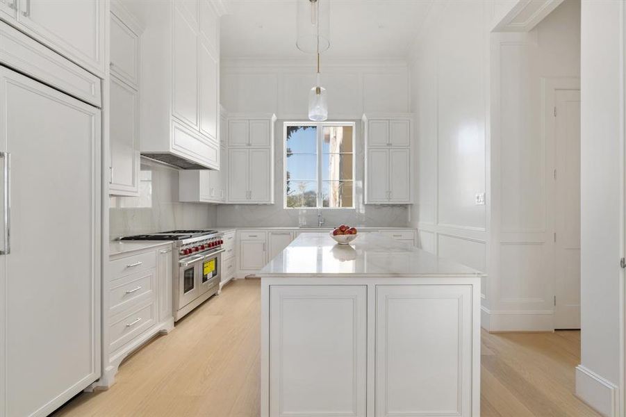 High-end luxury details include such features as imported marble countertops and backsplash, designer cabinets, and under-cabinet lighting + hidden outlet strips to maintain the clean and modern look. (photo of interior model home with smaller floor plan)