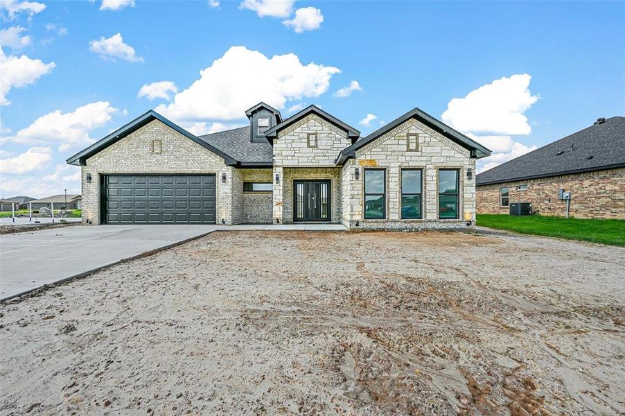 French country home featuring a garage and central AC unit