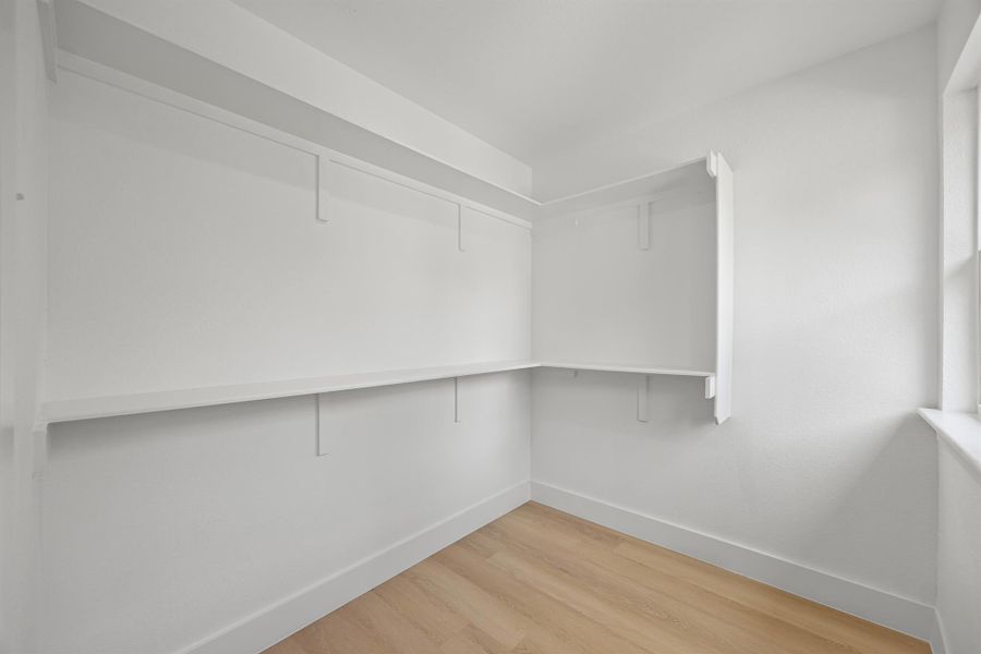 Spacious closet featuring light wood-style floors Spacious closet featuring light wood-style floors
