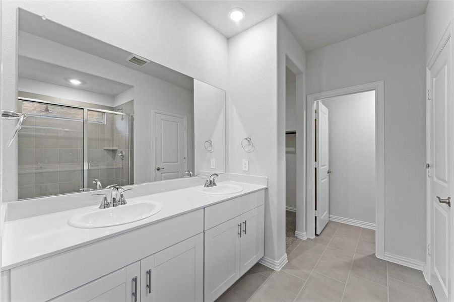 Full bathroom with double vanity, a shower stall, and tile patterned flooring Full bathroom with double vanity, a shower stall, and tile patterned flooring
