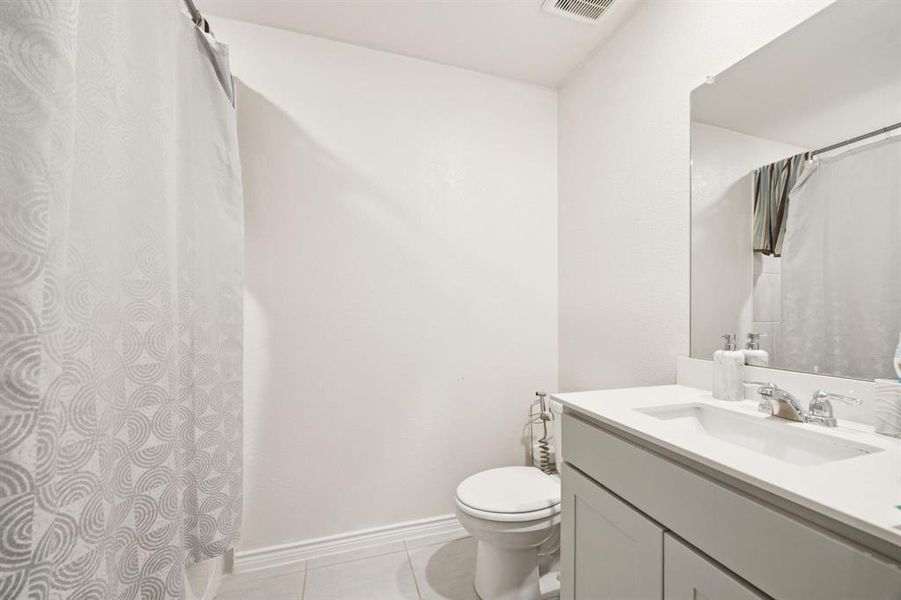 Full bath featuring light tile patterned floors and vanity