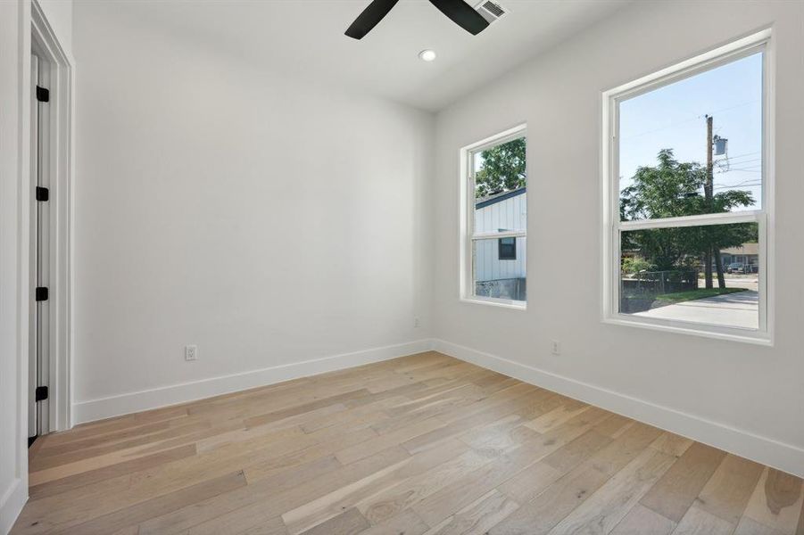 Empty room with ceiling fan and light wood-type flooring