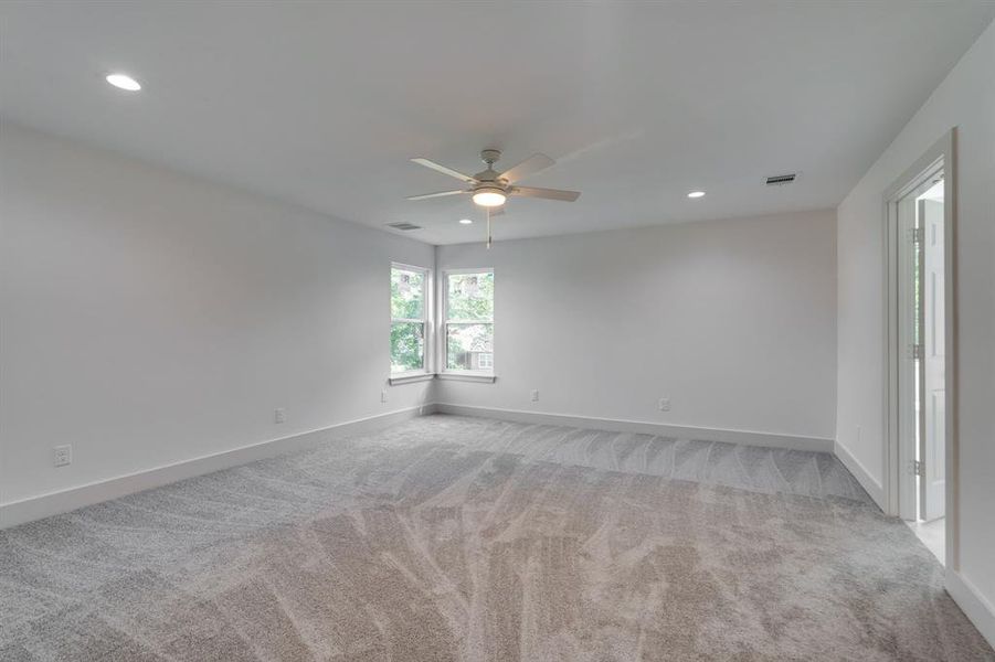 Carpeted spare room featuring ceiling fan