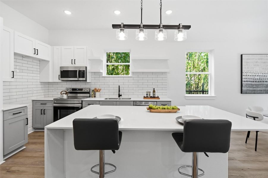 Open concept kitchen, dining and living room, with lots of natural light.