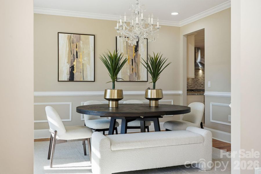 Formal dining room with wainscoting, statement chandelier, and seating for entertaining. Formal dining room with wainscoting, statement chandelier, and seating for entertaining.