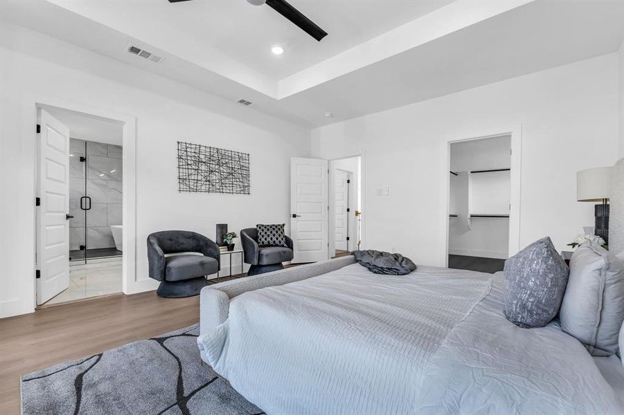 Bedroom with ceiling fan, wood-type flooring, and ensuite bath