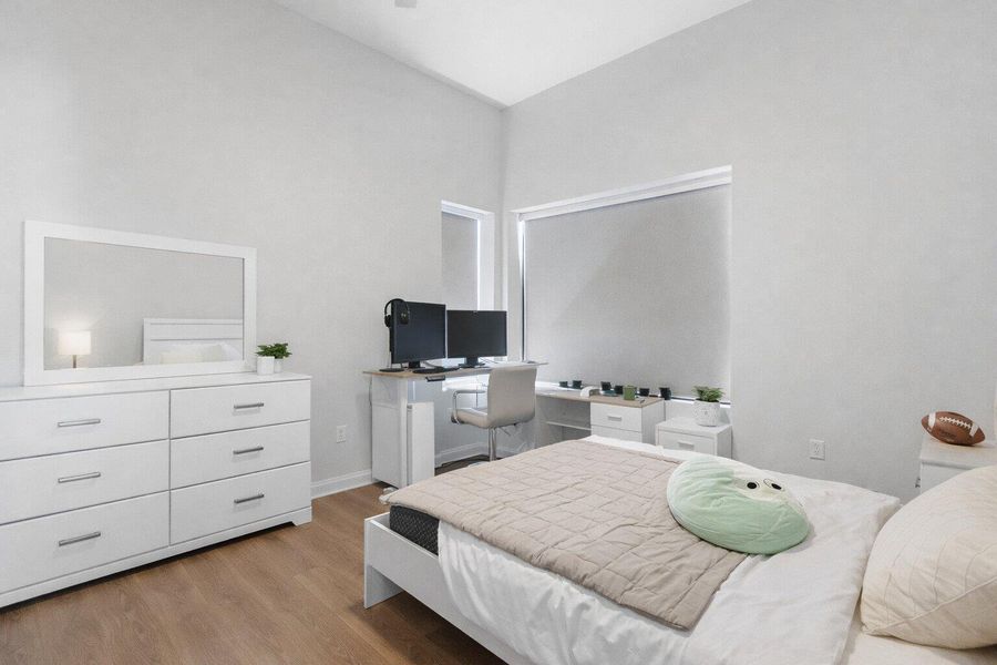 Bedroom featuring light wood finished floors and a desk