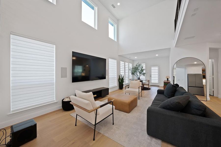 Soaring two-story ceiling and abundant natural light highlight this spacious living area