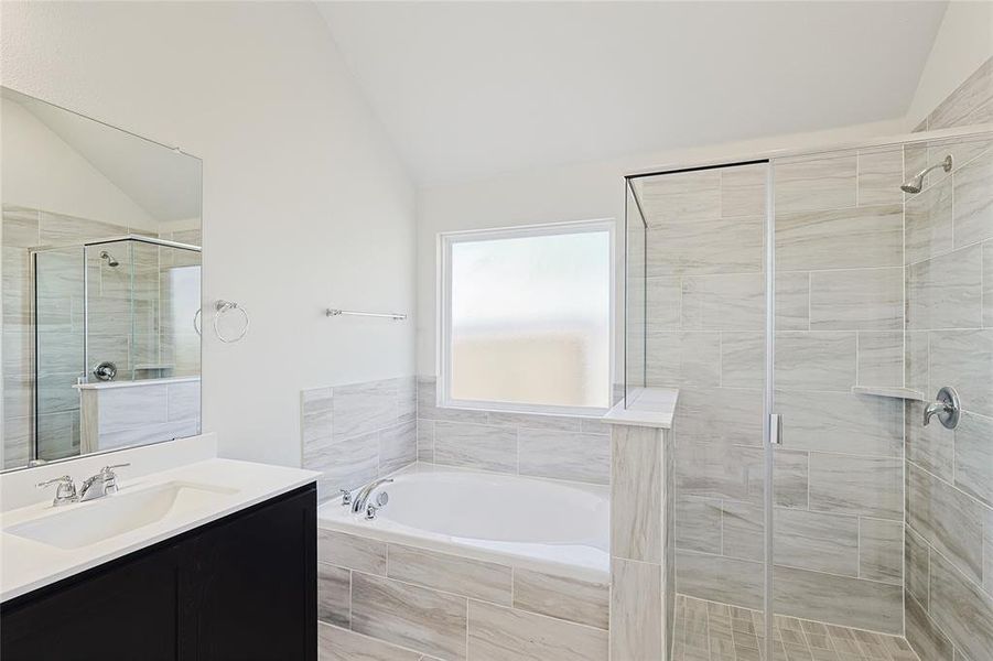 Bathroom featuring vanity, lofted ceiling, and shower with separate bathtub