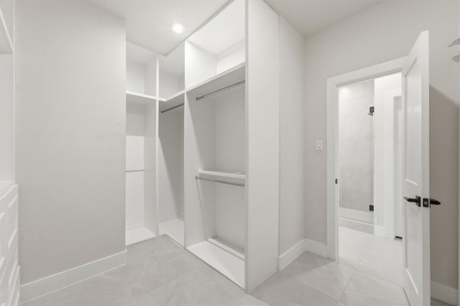 Custom walk-in closet featuring built-in shelving, hanging areas, and organized storage zones, seamlessly connected to the luxurious primary suite.