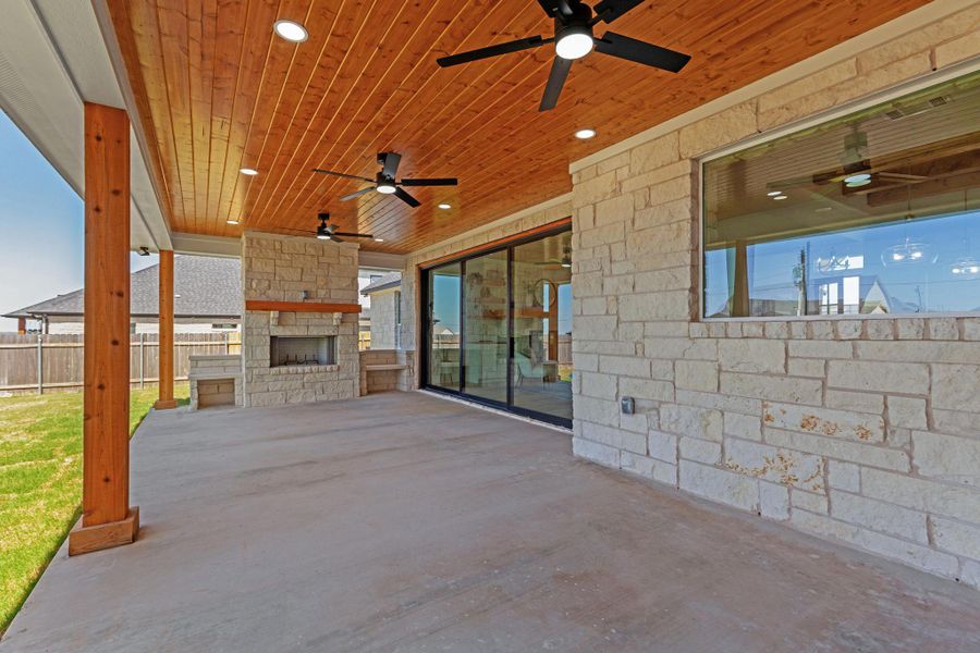View of patio with an outdoor stone fireplace and ceiling fan View of patio with an outdoor stone fireplace and ceiling fan