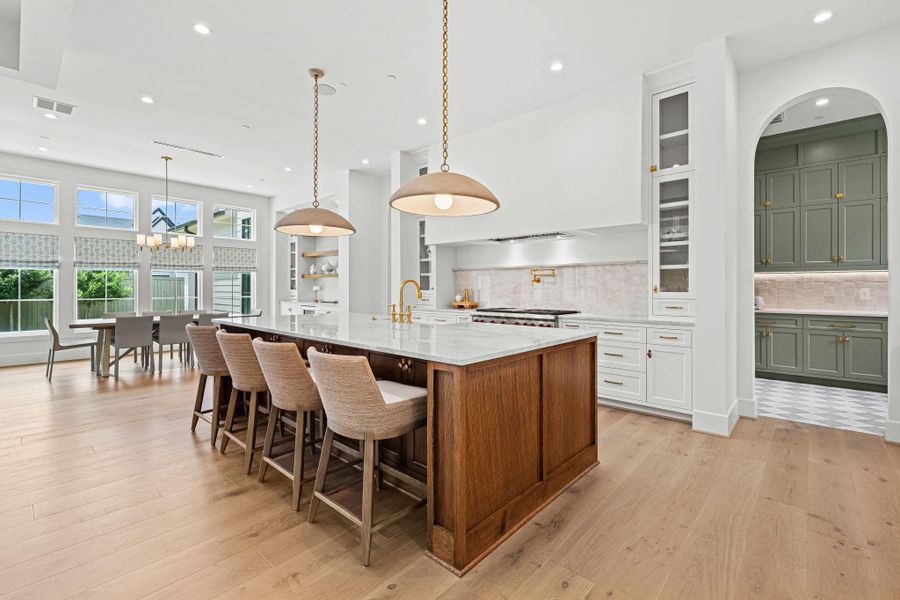 Designed for both everyday living & entertaining, this chef's kitchen offers a seamless open layout w/ the family room & breakfast area. Taj Mahal quartzite countertops & backsplash pair beautifully w/ custom cabinetry, while two Visual Comfort pendants highlight the expansive island. A clean, timeless design w/ elevated finishes throughout. Designed for both everyday living & entertaining, this chef's kitchen offers a seamless open layout w/ the family room & breakfast area. Taj Mahal quartzite countertops & backsplash pair beautifully w/ custom cabinetry, while two Visual Comfort pendants highlight the expansive island. A clean, timeless design w/ elevated finishes throughout.