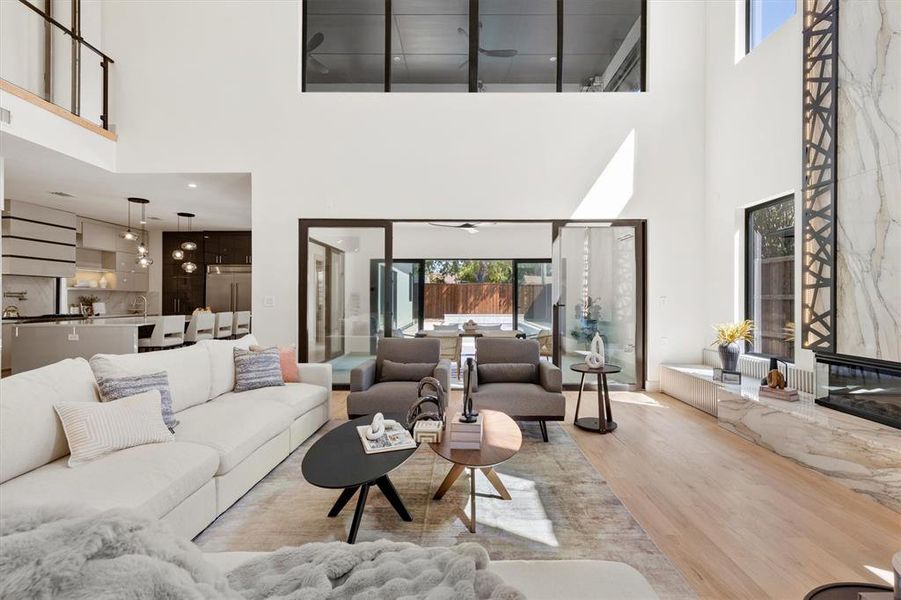 Living room with a towering ceiling and light hardwood / wood-style floors