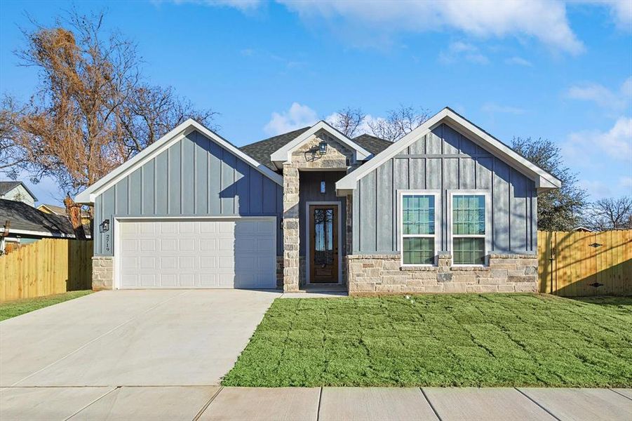 View of front facade featuring a garage and a front yard