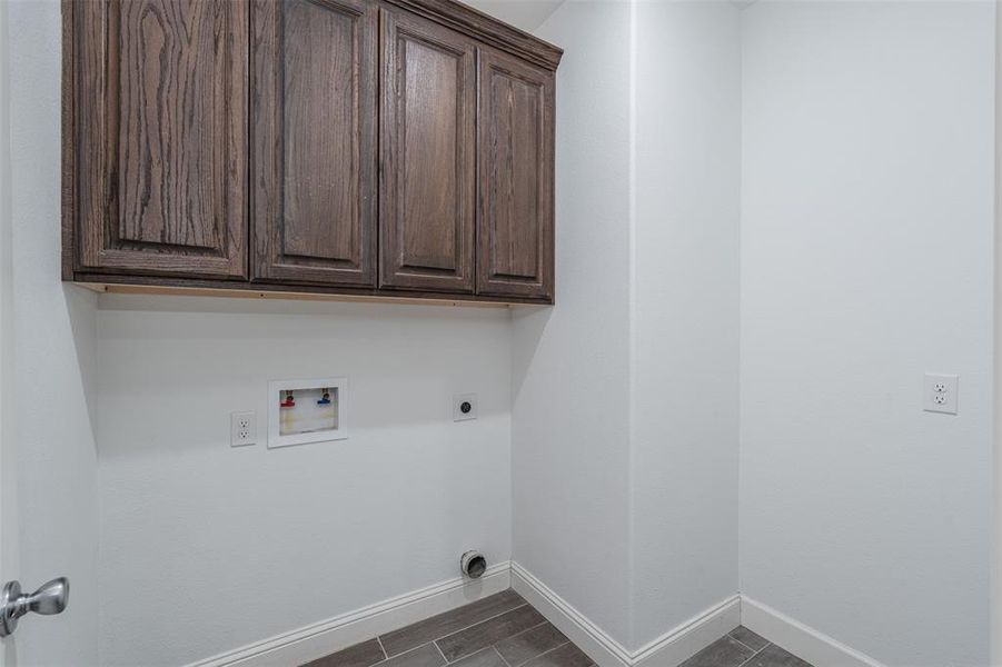 Laundry room featuring baseboards, washer hookup, cabinet space, and hookup for an electric dryer