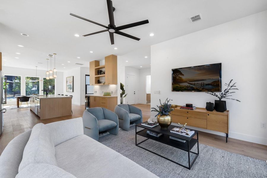 Living room featuring light wood-style floors, a ceiling fan, and recessed lighting Living room featuring light wood-style floors, a ceiling fan, and recessed lighting
