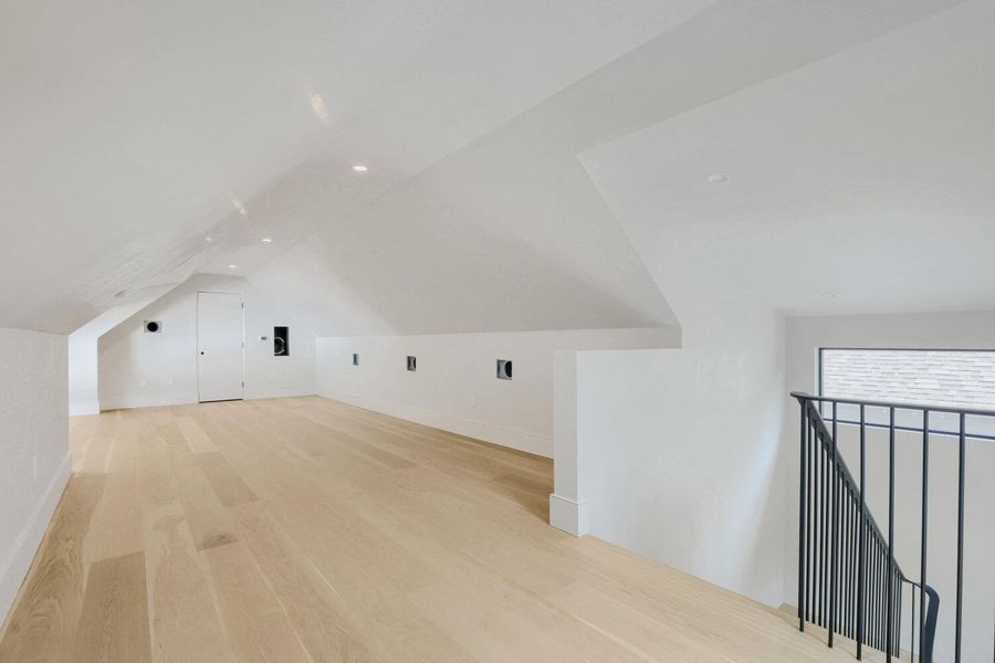 A spacious attic conversion offers versatile living with sloped ceilings and gleaming hardwood floors.