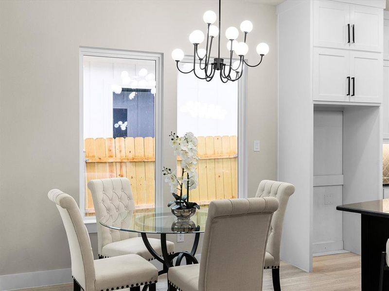 Dining room featuring a chandelier, light wood finished floors, and healthy amount of natural light